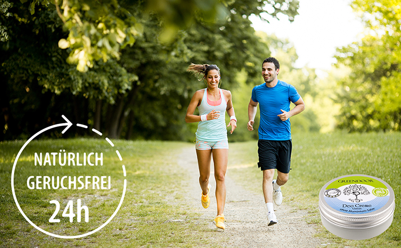 970_600_young-couple-running_24h_Packshot-kl-Datei Fröhliches joggendes Paar mit einem Hinweis 24 Stunden natürlich geruchsfrei und einer abgelideten Packung Greendoor Deo Creme classic