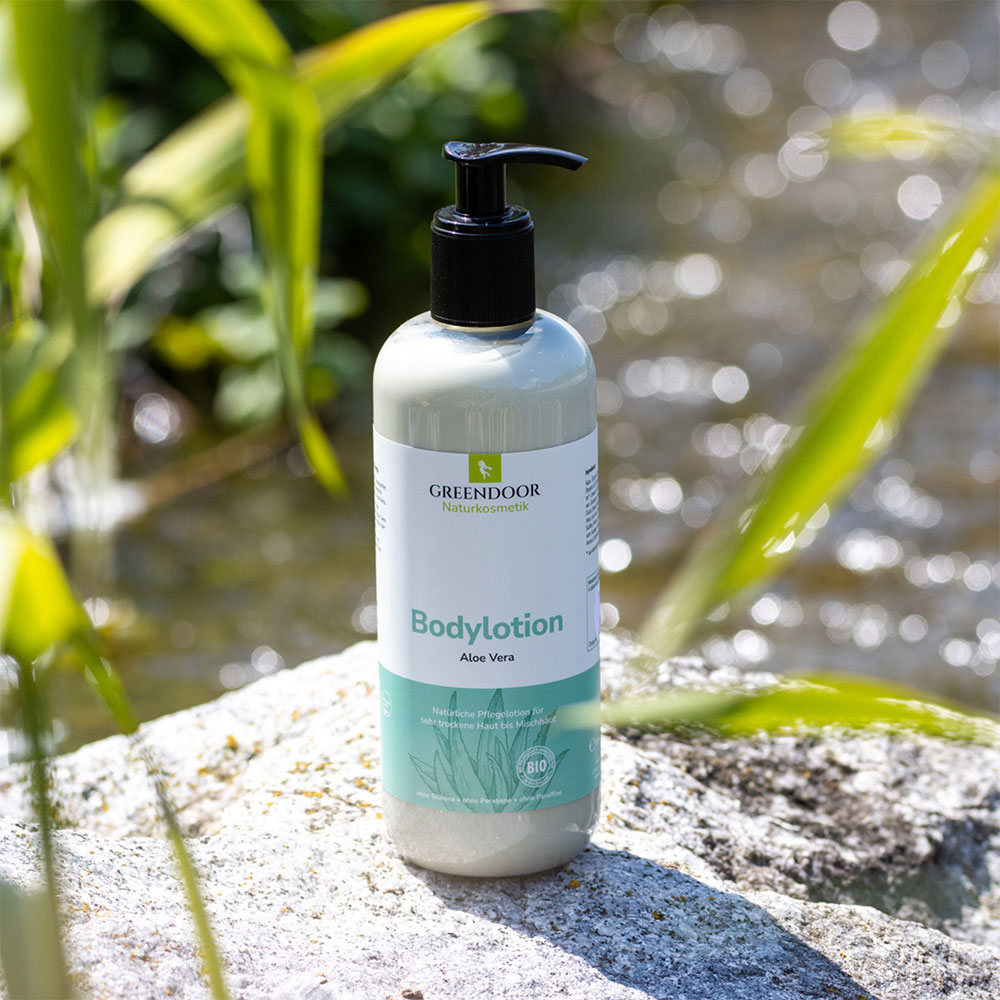 große Flasche mit Pumper Greendoor Bodylotion Aloe Vera Moodbild vor Wasser