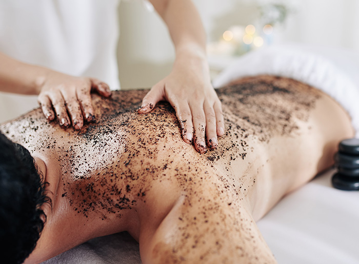 Männerrücken wird mit Kaffeescrub behandelt