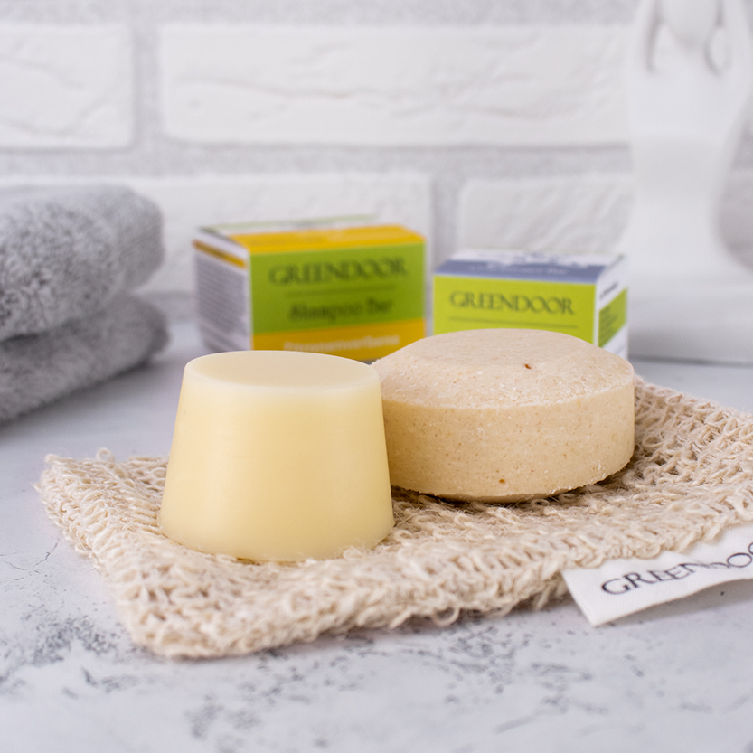 Greendoor Shampoo Bar und Greendoor Conditioner Bar, ausgepackte Produkte plus Faltschachteln