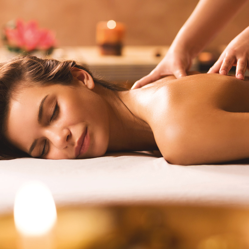 Junge Frau auf Massageliege mit geschlossenen Augen und genießender Mimik