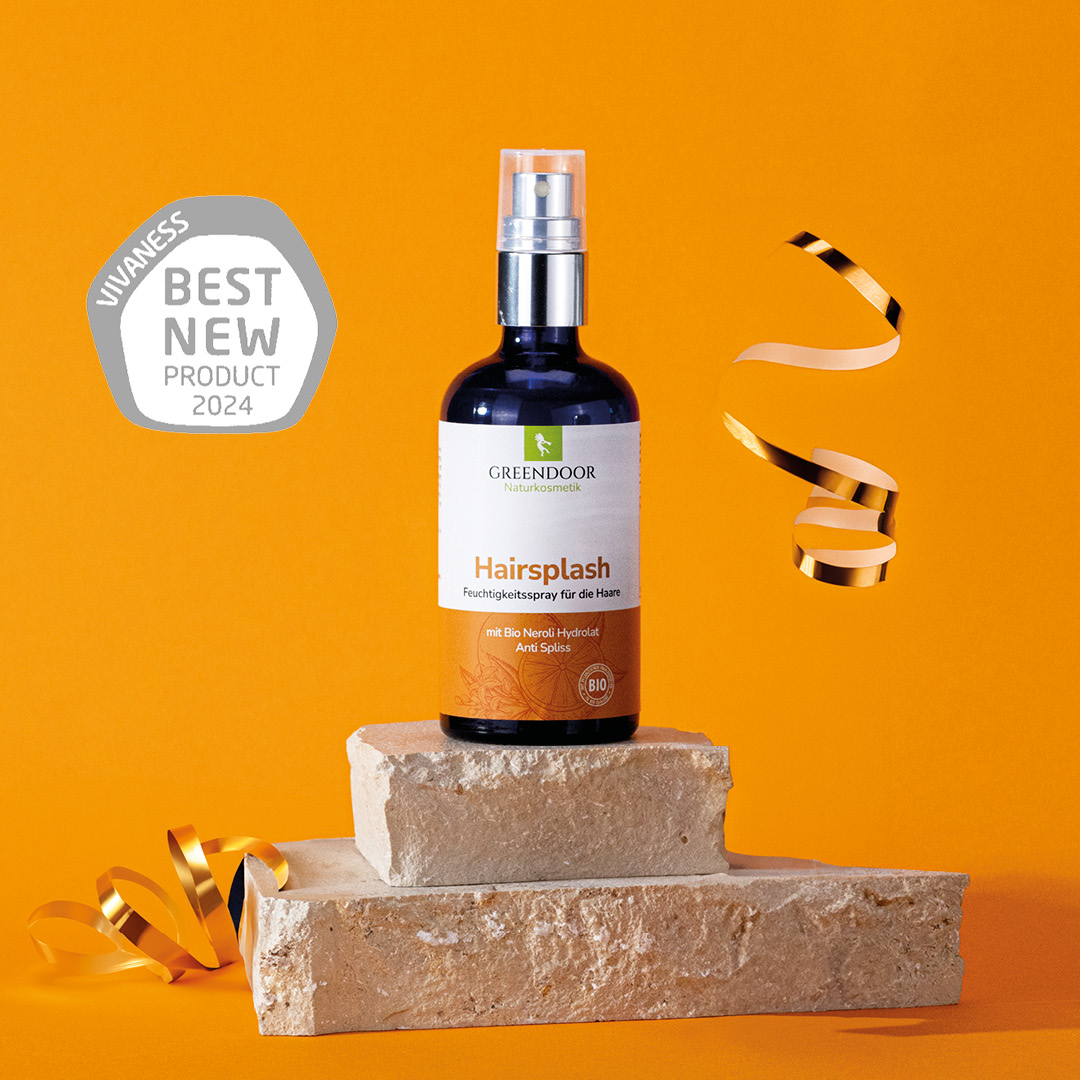 Greendoor Hairsplash Flasche steht auf Steinsockel zusammen mit Siegel Best New Product 2024