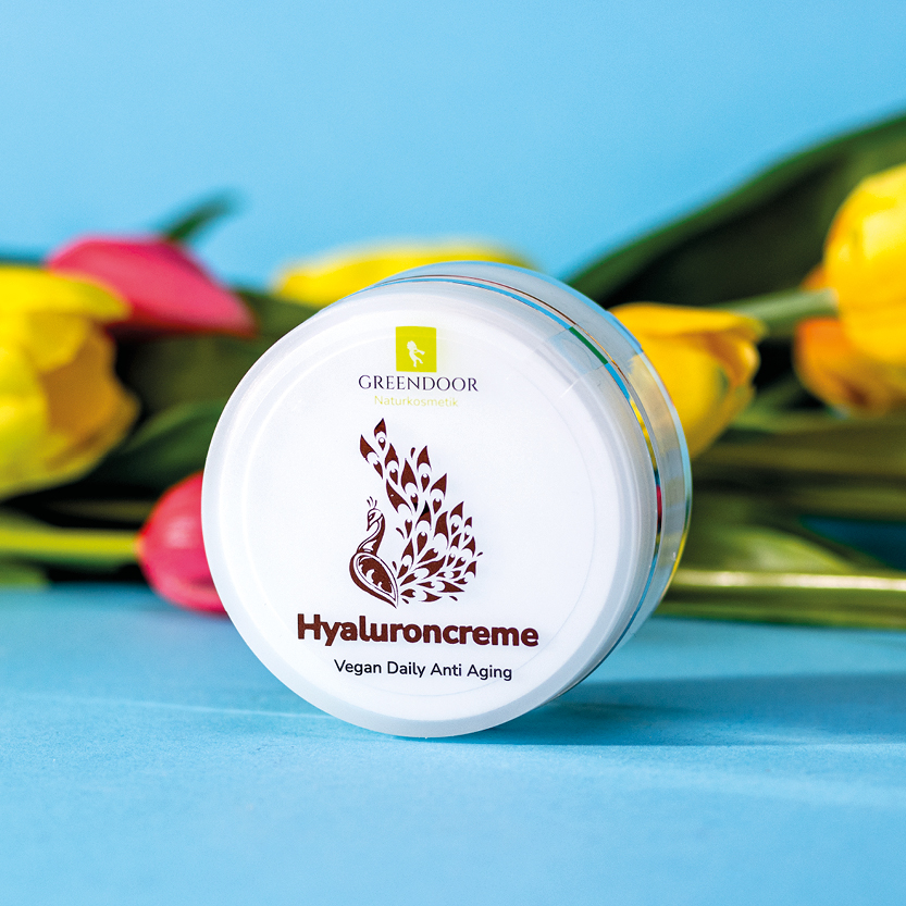 Greendoor Hyaluroncreme vor einem liegenden Tulpenstrauß